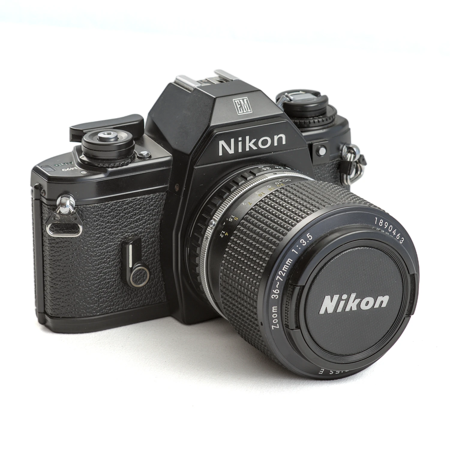Appareil photo reflex argentique Nikon EM de trois-quarts avec objectif