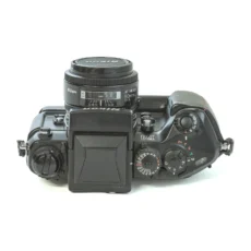 Nikon F4s de face avec son bouchon d'objectif posé à côté