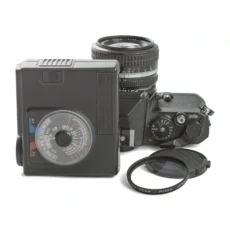 Ensemble Nikon FE avec flash SB-15 posé à côté et filtre UV L37c