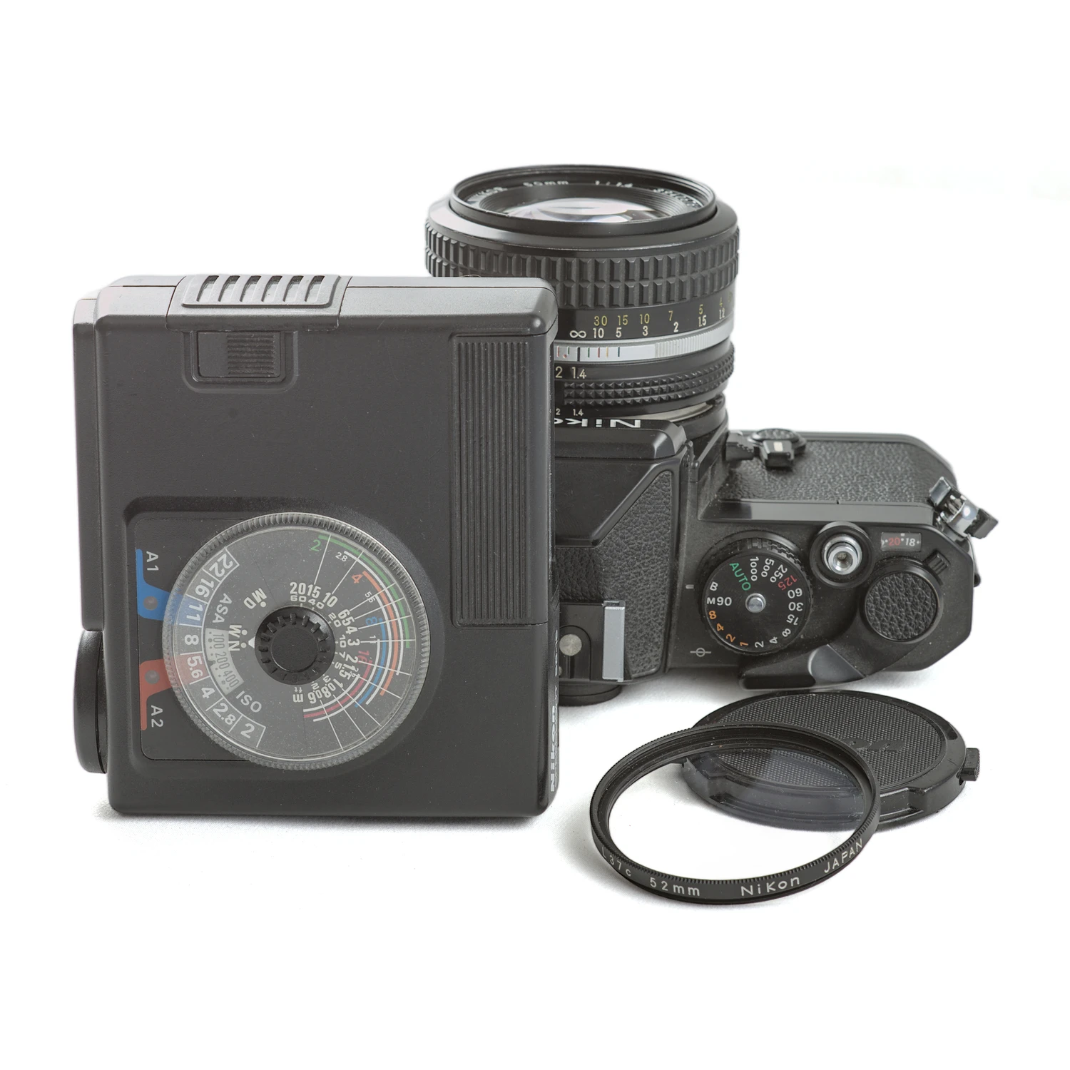Ensemble Nikon FE avec flash SB-15 posé à côté et filtre UV L37c