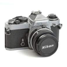 Appareil photo reflex Nikon FE argentique de face avec son bouchon d'objectif