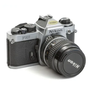 Appareil photo reflex argentique Nikon FE2 de trois quarts face avec son objectif