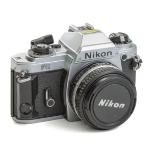 Appareil photo reflex argentique Nikon FG de face avec son bouchon d'objectif