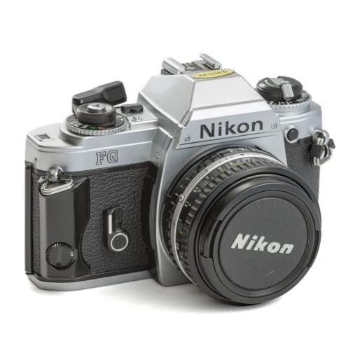 Appareil photo reflex argentique Nikon FG de face avec son bouchon d'objectif