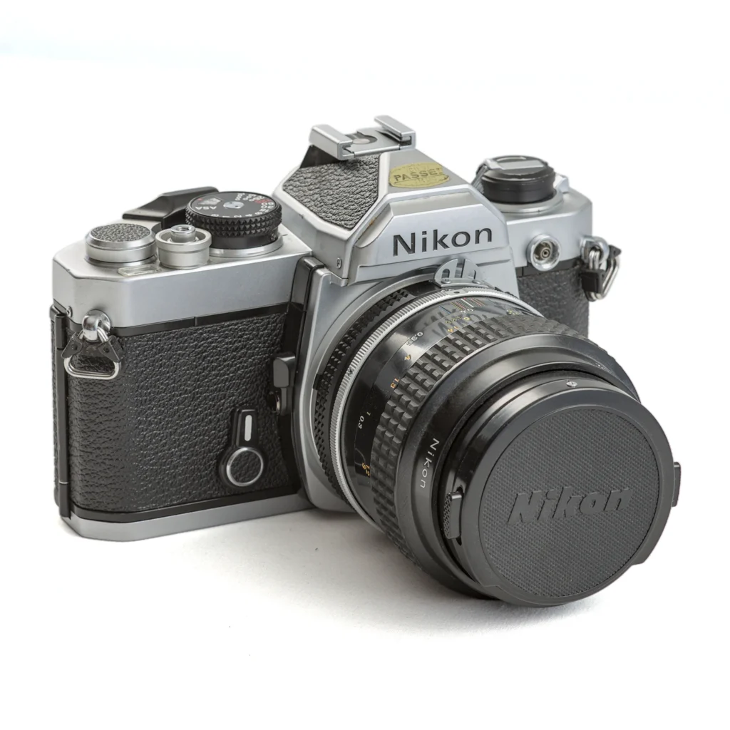 Appareil photo reflex argentique Nikon FM de trois-quarts avec objectif Micro-Nikkor