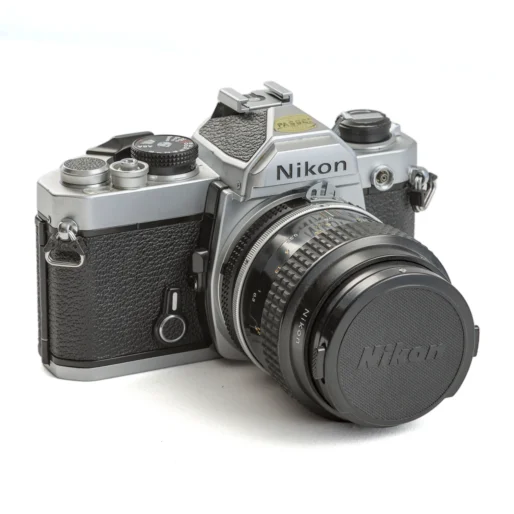 Appareil photo reflex argentique Nikon FM de trois-quarts avec objectif Micro-Nikkor